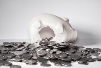 Piggy bank with money spilling out